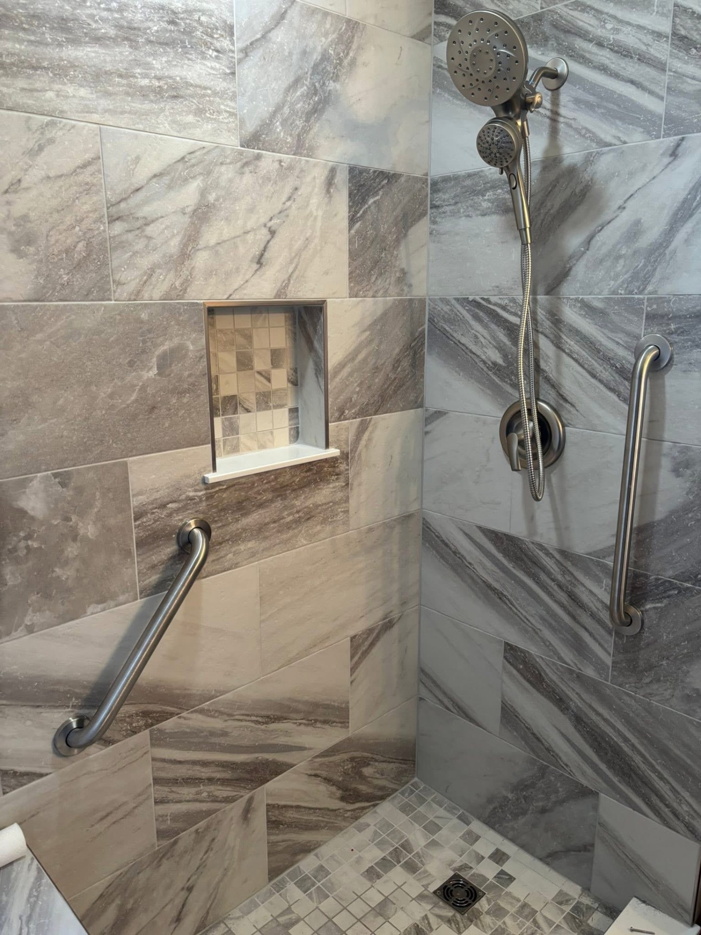 Tile shower detail: custom mosaic niche, grab bars, mosaic floor